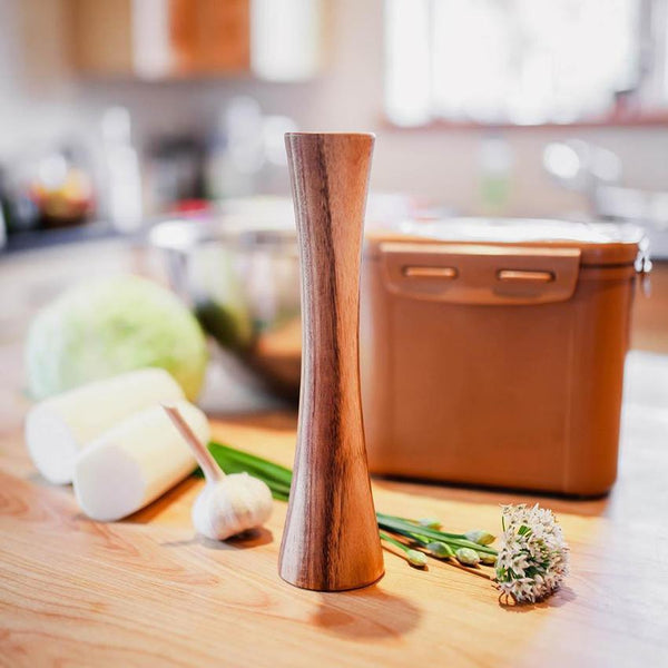 Pilon en bois pour fermentation avec contenant de fermentation et légumes